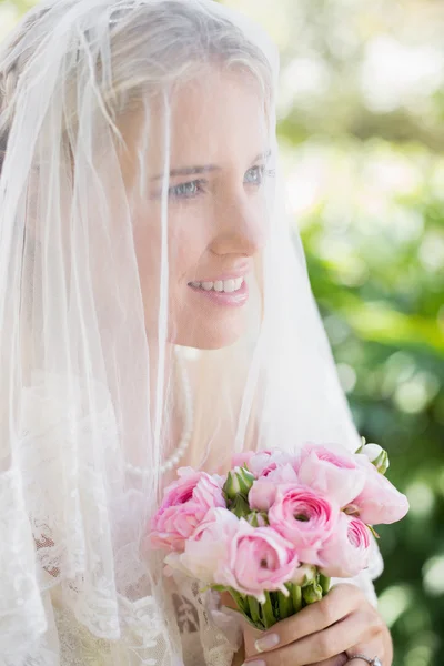 Contenuto sposa indossa velo sul viso tenendo bouquet rosa — Foto Stock