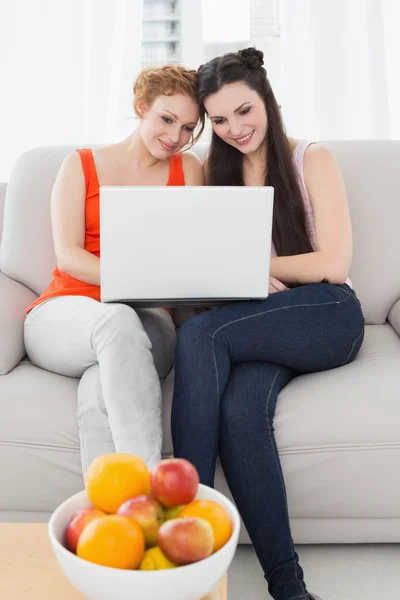 Amigos femeninos usando el ordenador portátil juntos en casa —  Fotos de Stock