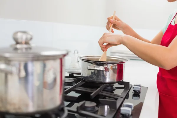 Seção média de uma mulher preparando comida na cozinha — Fotografia de Stock