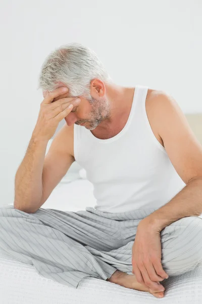 Zralý muž trpí bolest hlavy v posteli — Stock fotografie