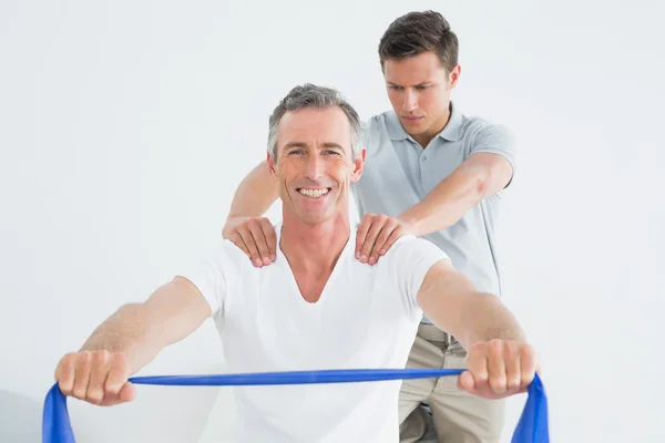 Therapist massaging mans shoulder in gym hospital — Stock Photo, Image