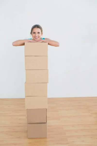 Vrouw in een nieuw huis met een stapel van vakken verplaatsen — Stockfoto