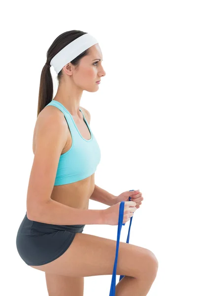 Ajuste mujer joven que hace ejercicio con un cinturón de yoga azul — Foto de Stock