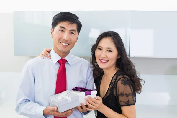 Retrato de una pareja con caja de regalo en la cocina — Foto de Stock