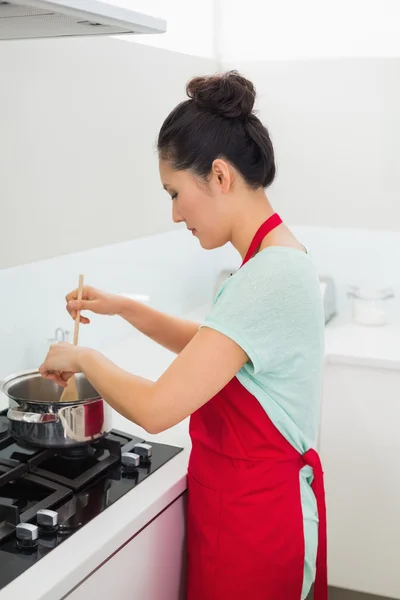 Вид сбоку на женщину, которая готовит еду на кухне — стоковое фото