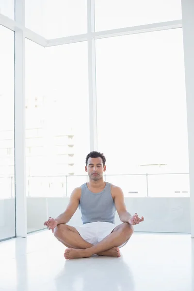 Full length of a young man sitting in lotus pose — Stock Photo, Image