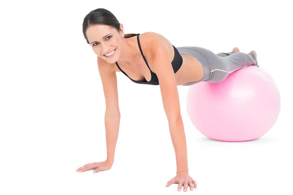 Fit woman doing push ups on fitness ball — Stock fotografie