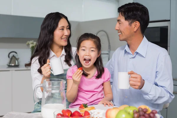 Portrait of a happy girl enjoying breakfast with parents — Stock Photo, Image