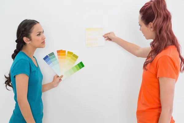 Dos amigas eligiendo el color para pintar una habitación —  Fotos de Stock