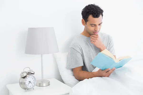 Rahat adam yatakta kitap okumak — Stok fotoğraf