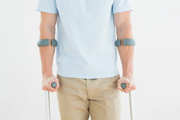 Close-up mid section of a man with crutches — Stock Photo, Image