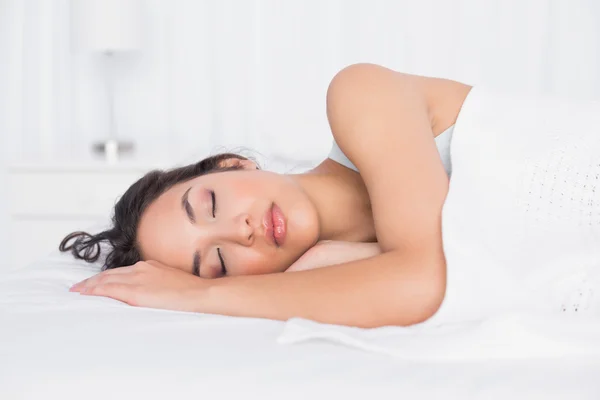 Mooie jonge vrouw slapen met de ogen gesloten in bed — Stockfoto