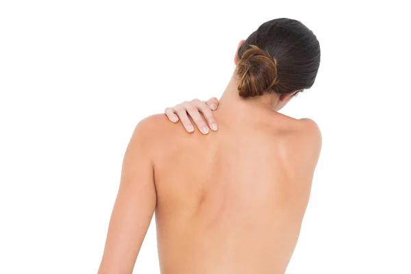 Rear view of a topless fit woman with shoulder pain — Stock Photo, Image