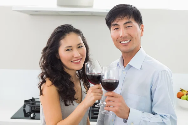 Loving young couple with wine glasses in kitchen — Stock Photo, Image