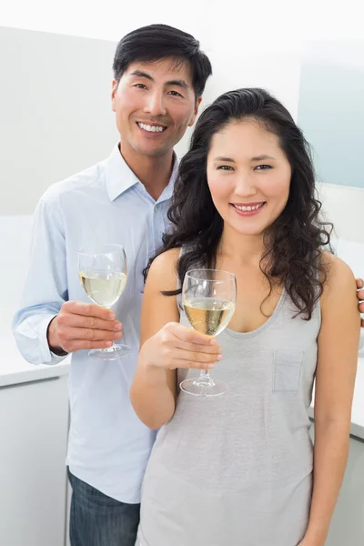 คู่รักหนุ่มสาวกับแก้วไวน์ในครัว — ภาพถ่ายสต็อก
