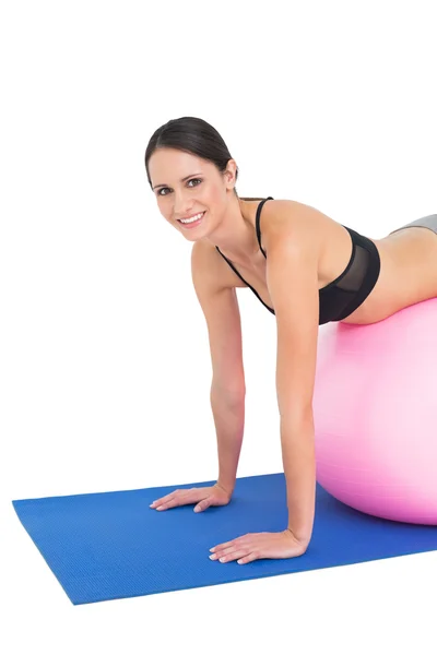 Portrait of a fit young woman stretching on fitness ball — Stock Photo, Image