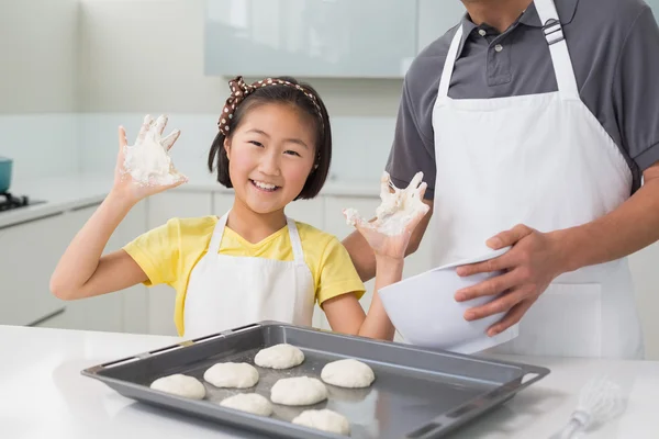 Menina alegre com seu pai preparando biscoitos na cozinha — Fotografia de Stock