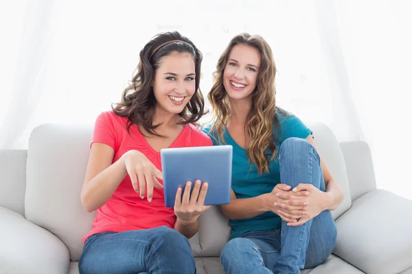 Leende kvinna vänner med digital tablet i vardagsrummet — Stockfoto