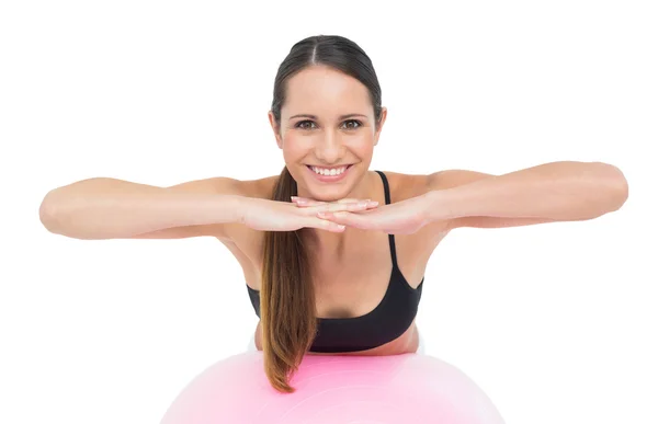 Leende passar ung kvinna stretching på fitness boll — Stockfoto