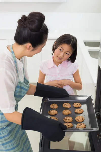 帮助她的妈妈准备在厨房里的饼干的女孩 — 图库照片