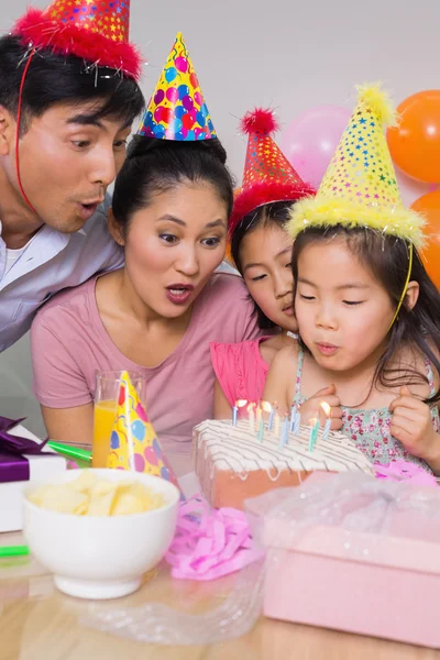 Family blowing cake at a birthday party — Stock Photo, Image