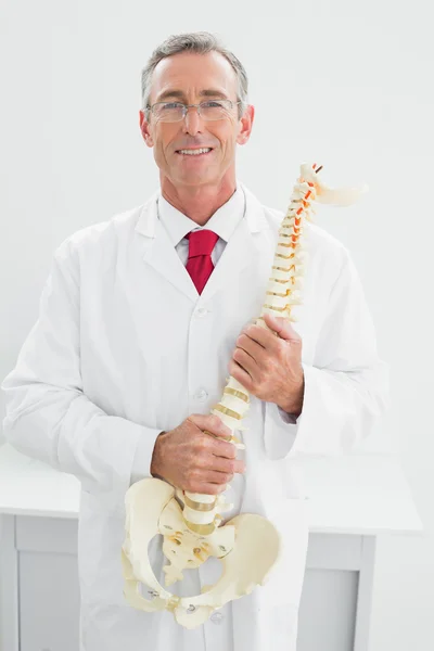 Hombre doctor holding esqueleto modelo en oficina — Foto de Stock
