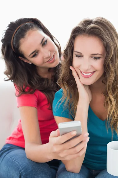 Female friends in sunglasses reading text message — Stock Photo, Image