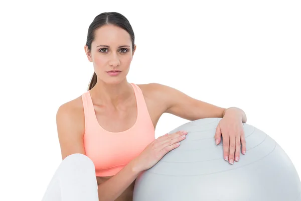 Retrato de una mujer en forma sentada con pelota de fitness — Foto de Stock