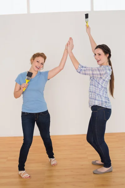 Female friends giving high five in a new house — Stock Photo, Image