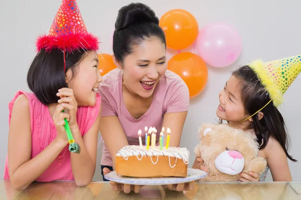 Mädchen schauen Mutter bei Geburtstagsparty mit Kuchen an — Stockfoto