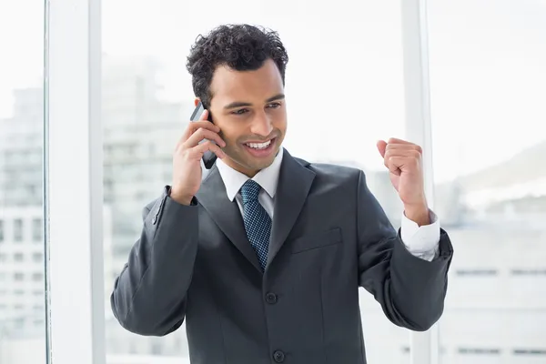Элегантный молодой бизнесмен, использующий мобильный телефон в офисе — стоковое фото