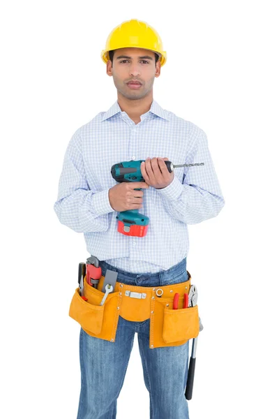 Serious handsome young handyman holding drill — Stock Photo, Image