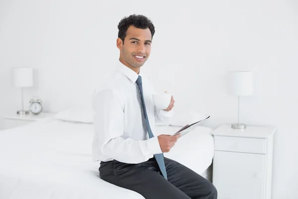 Businessman with cup reading newspaper at hotel room — Stock Photo, Image