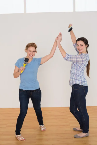 Female friends giving high five in a new house — Stock Photo, Image