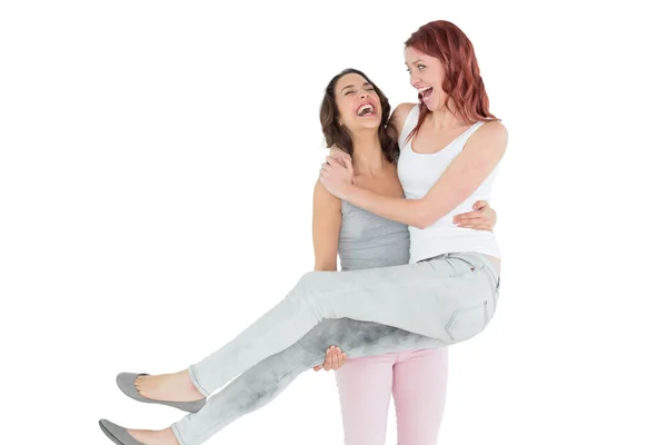 Cheerful young female carrying her happy friend — Stock Photo, Image