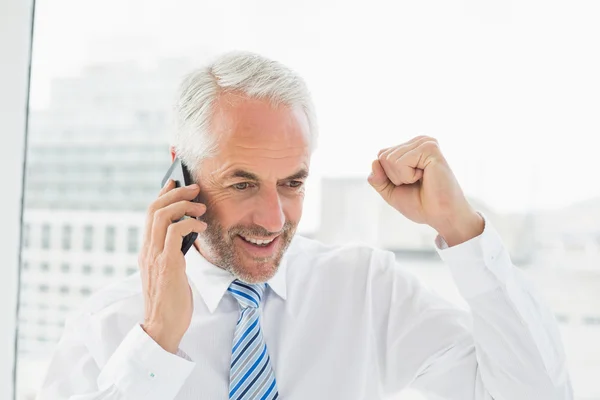 Empresário feliz usando telefone celular no escritório — Fotografia de Stock