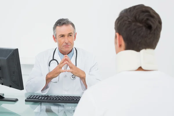 Médico ouvindo paciente com concentração no consultório — Fotografia de Stock