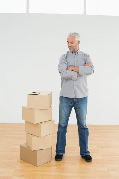 Mature man with boxes in a new house — Stock Photo, Image