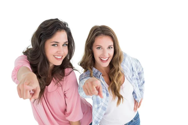 Kvinnliga vänner pekar mot vit bakgrund — Stock fotografie