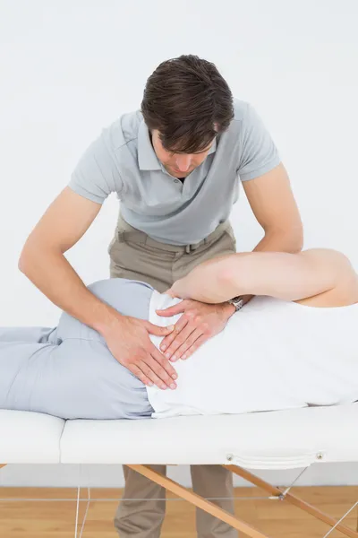 Fisioterapeuta masculino examinando mans espalda — Foto de Stock
