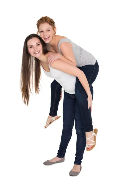 Volledige lengte portret van een jonge vrouwelijke piggybacking vriend — Stockfoto