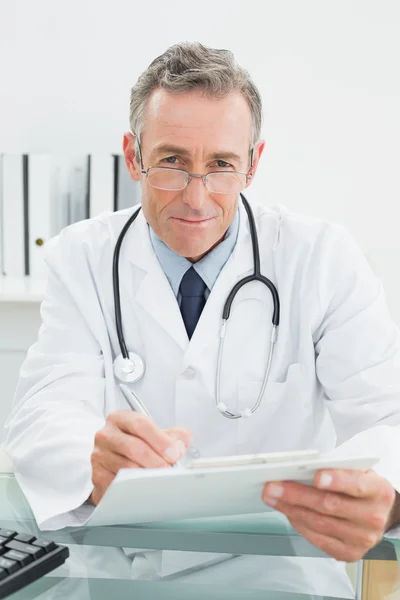 Doctor reading a report at medical office — Stock Photo, Image