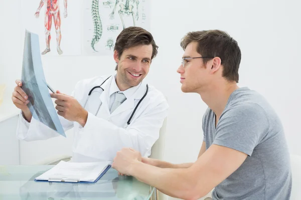 Male doctor explaining spine x-ray to patient — Stockfoto