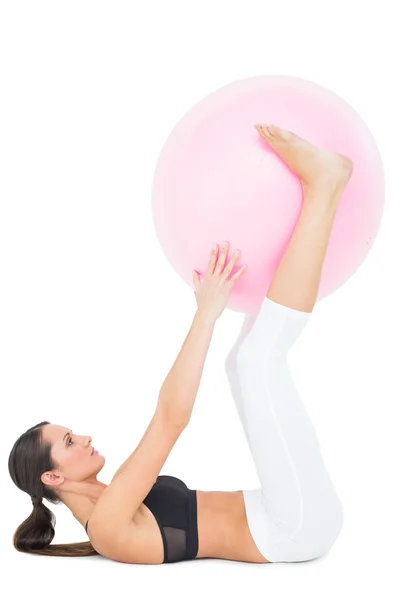 Side view of a fit woman exercising with fitness ball — Stock Photo, Image