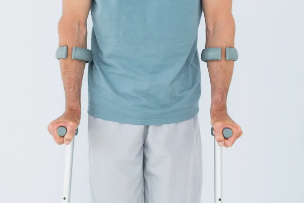 Close-up mid section of a man with crutches — Stock Photo, Image