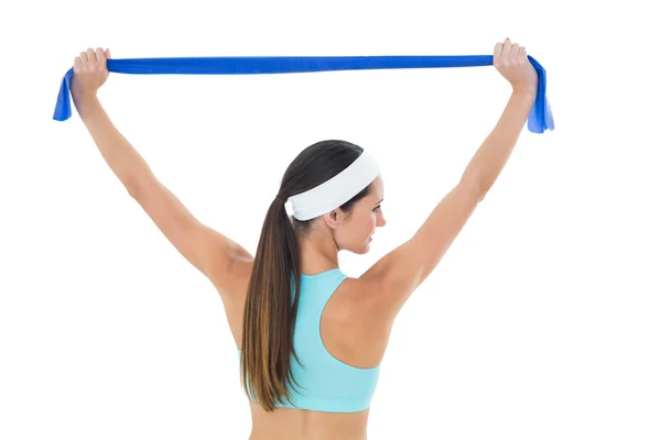 Fitte junge Frau hält einen blauen Yoga-Gürtel hoch — Stockfoto