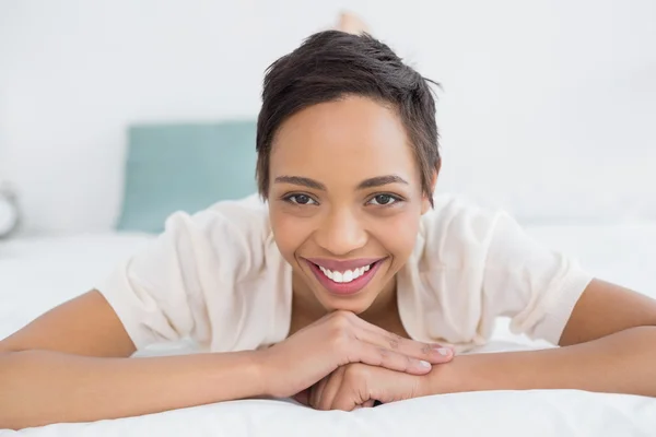 Lachende mooie jonge vrouw ontspannen in bed — Stockfoto