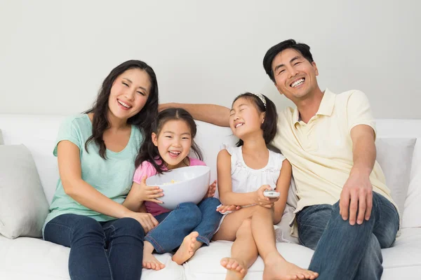 Happy family of four watching tv in living room — Stock Photo, Image