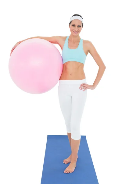 Retrato de una mujer en forma sonriente sosteniendo una pelota de fitness —  Fotos de Stock