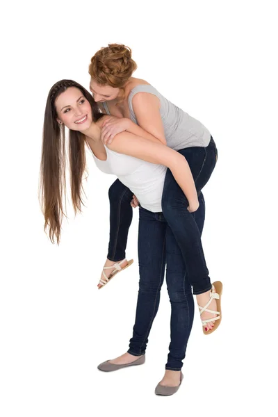 Longitud completa de una joven amiga piggybacking —  Fotos de Stock